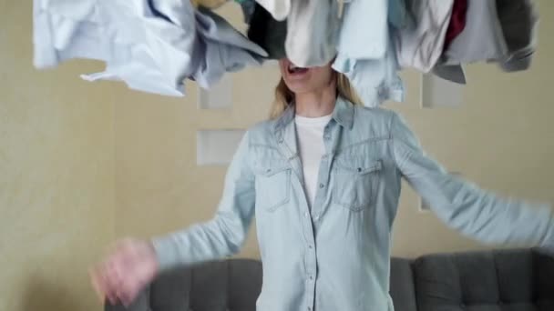 Une femme agressive jette ses sous-vêtements en l'air. Le concept de nettoyage à domicile et de blanchisserie . — Video