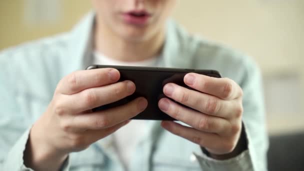 Glada glad, leende ung kvinna spelar smartphone spel, hålla mobiltelefon horisontellt som passerar ras nivå, bilar spel. — Stockvideo