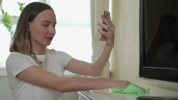 Femme nettoie l'appartement et parle au téléphone — Video