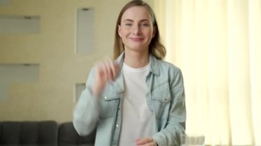 Video blogları, iletişim ve insanların konsepti. Mutlu gülümseyen genç bir kadın evde konuşuyor.