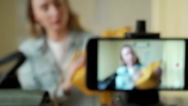 Een vrouwelijke blogger toont modetassen live op social media opnemen van haar verkoop online met behulp van een digitale camera — Stockvideo