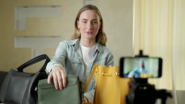 Μια γυναίκα blogger δείχνει τσάντες μόδας ζωντανά στα μέσα κοινωνικής δικτύωσης να καταγράφουν την πώλησή της στο διαδίκτυο χρησιμοποιώντας μια ψηφιακή κάμερα — Αρχείο Βίντεο