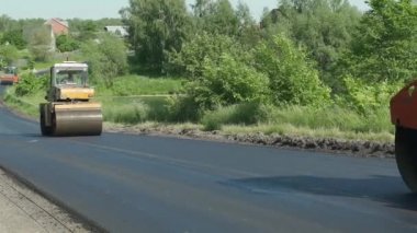 Buz pateni pistinin büyük çalışma makinesi yeni bir asfalt yapar. Yol tamiri. Yakın plan.