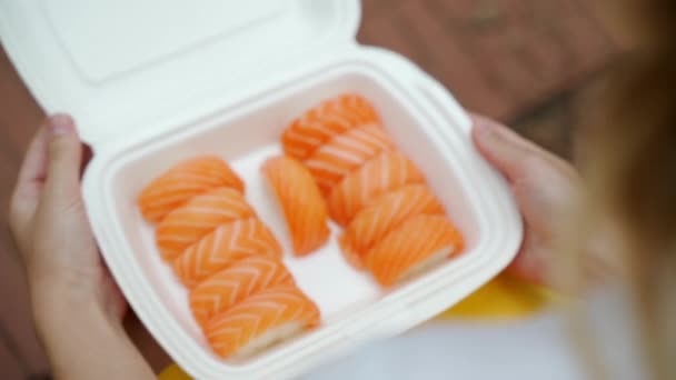 Abre o pacote com rolos e sushi e mãos leva-los — Vídeo de Stock