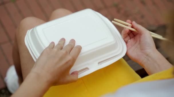 Открывает упаковку с рулонами и суши и руки берет их — стоковое видео