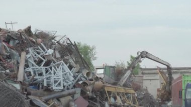 Makineye bak, hidrolik yakalama pençeli yükleyici manipülatörü eski çeliği topluyor, hareket ettiriyor, hurda metali.