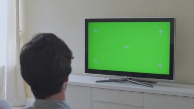 Oturma odasında oturan çift Yeşil Krom Anahtar Ekran Televizyonu 'nu izliyor. Çift Odalı TV Şovu ya da Film İzleme.