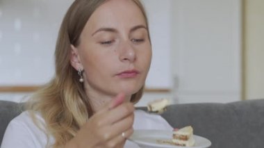 Mutfakta pasta yiyen mutlu kadın. Pastadan hoşlanan bayan