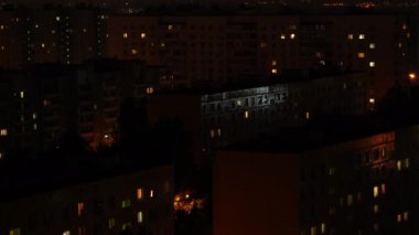 Çok katlı bir binanın penceresinde gece vakti ışık çarpması. Büyük bir şehirde hayat