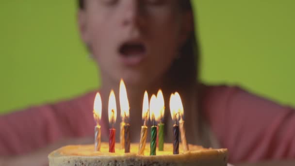 Soplando velas en un pastel de cumpleaños — Vídeo de stock