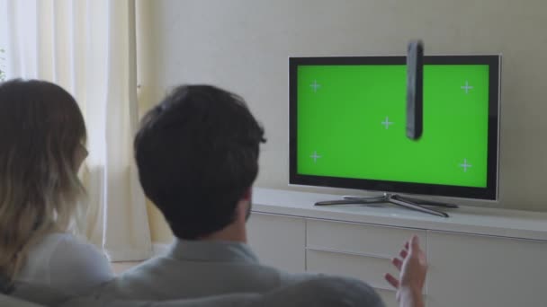 Coppia seduta a casa in salotto a guardare verde croma chiave schermo televisivo. Coppia Stanza Guardando TV Show o un film. — Video Stock
