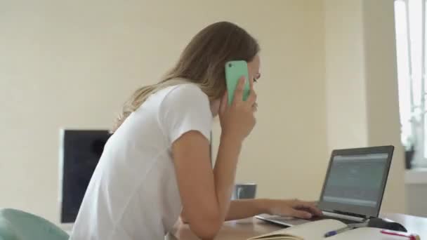 Mujer sentada en su escritorio en el estudio de la oficina en casa trabajando en una computadora portátil escribe notas. enérgico ritmo rápido time-lapse movimiento rápido hacia adelante. 360 grados de seguimiento tiro de arco — Vídeos de Stock