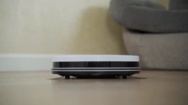 Robot temizleyicisi odayı temizliyor. Akıllı ev. Robot elektrikli süpürge daireyi otomatik olarak temizliyor. 