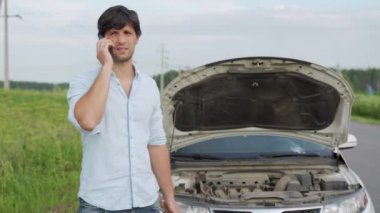 Bozuk arabanın yanında duran adam. Adam kaputu açtı ve motora baktı.. 