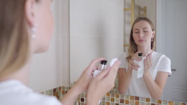 Mujer joven sonriente con aparatos ortopédicos limpiando sus dientes con riego de agua — Vídeos de Stock