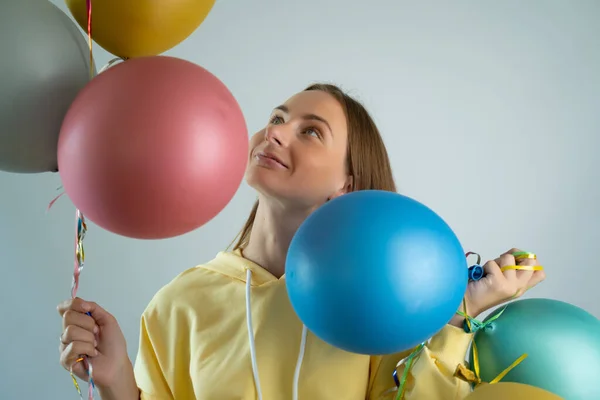 Красотка с красочными воздушными шарами кружатся и смеются. Счастливая молодая женщина на дне рождения. — стоковое фото