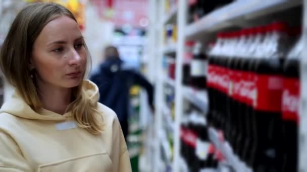 Una donna compra una coca analcolica sugli scaffali di un supermercato. — Video Stock