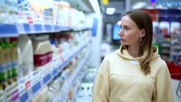 Mujer haciendo compras en el supermercado y leyendo etiquetas de alimentos, nutrición y concepto de calidad — Vídeos de Stock