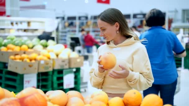 Mulher comprando frutas cítricas frescas - toranja no supermercado. Conceito de saúde — Vídeo de Stock