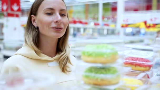 Kobieta kupująca pączki w dziale Ciasta — Wideo stockowe