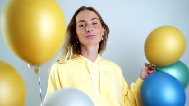 Schöne Frau mit bunten Luftballons, die sich drehen und lachen. Schöne Happy Young Frau auf Geburtstagsparty. Zeitlupenvideo — Stockvideo