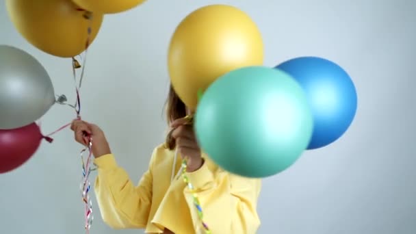 Красотка с красочными воздушными шарами кружатся и смеются. Поздравляю молодую женщину с днем рождения. Видео замедленного действия — стоковое видео