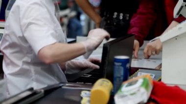 Süpermarkette kasiyerlerin kasiyerleri bakkaliyeleri ve diğer sağlıklı yiyecek maddelerini tarıyor..