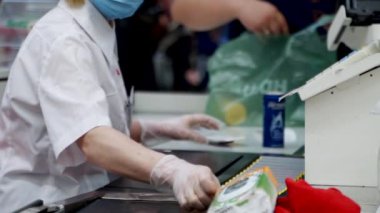 Süpermarkette kasiyerlerin kasiyerleri bakkaliyeleri ve diğer sağlıklı yiyecek maddelerini tarıyor..
