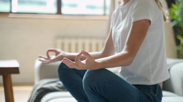 Atractiva joven mujer haciendo ejercicio y sentada en posición de loto de yoga — Foto de Stock