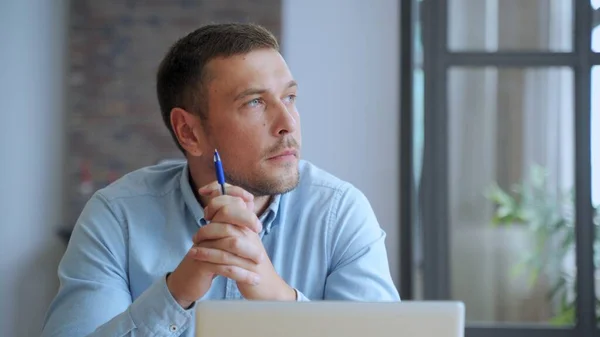 Hombre serio estudiante sentarse en el escritorio de la oficina en casa con el ordenador portátil pensando en la inspiración solución de problemas de búsqueda ideas perdidas en los pensamientos. — Foto de Stock