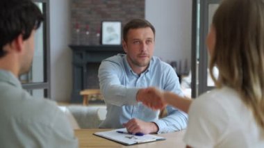 Emlakçıdan ev almak için gerekli belgeleri imzaladıktan sonra anahtarı alan aile çifti..