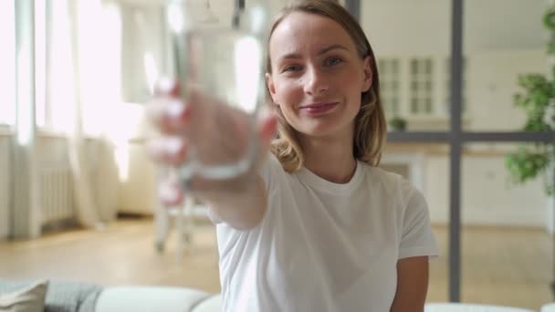 Jonge vrouw toont drinkglas met water — Stockvideo