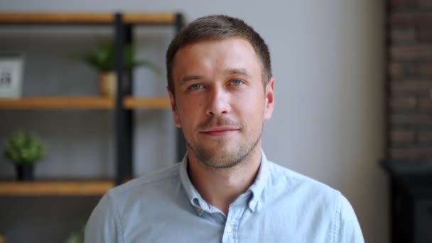 Portrait of young man smiling in house looking at camera standing alone. People, positive emotions and lifestyle concept. — Stock Video