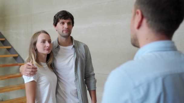 Pareja feliz recibiendo la llave del apartamento del agente de bienes raíces. Pareja feliz sonriendo y consiguiendo llaves de nuevos bienes raíces de agente. — Vídeos de Stock