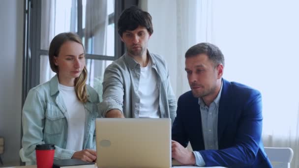 Genç iş adamları dizüstü bilgisayarla çalışıyorlar ve ofiste yeni projelerinden bahsediyorlar.. — Stok video