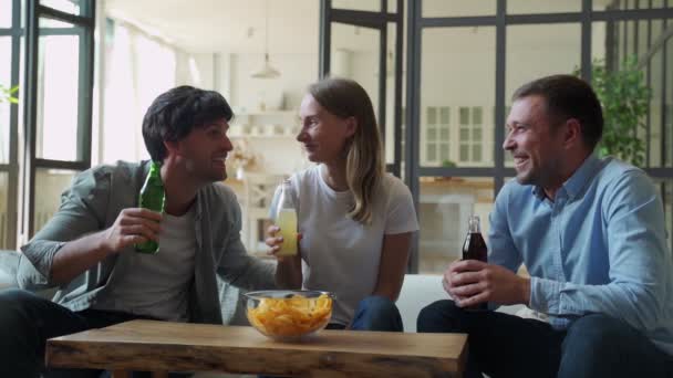 Drie vrienden praten met elkaar en eten thuis. — Stockvideo