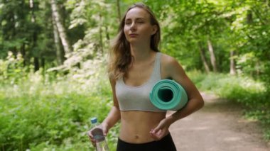 Üniformalı güzel bir bayan sporcu antrenman için parka gider.