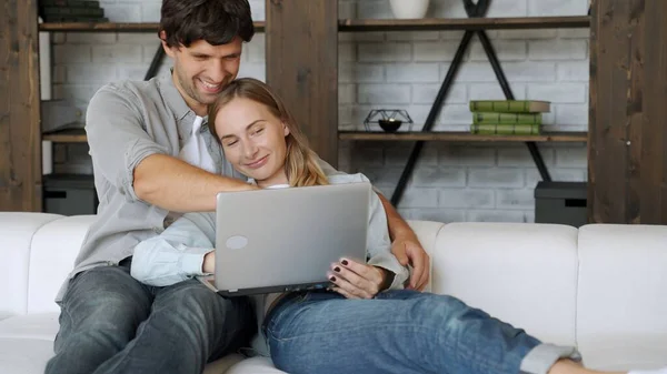 年轻夫妇在家里放松，看笔记本电脑 — 图库照片