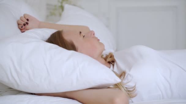 Mooie vrouw met slapeloosheid kan 's nachts niet slapen. Ze gooit en draait in bed. — Stockvideo