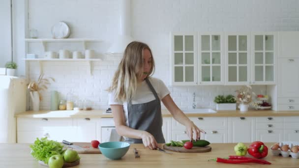 Jonge grappige vrouw dansen en zingen met lepel terwijl het hebben van vrije tijd in de keuken thuis — Stockvideo