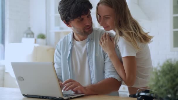 Casal jovem comemorando o sucesso, lendo boas notícias no e-mail, olhando para a tela do laptop, na cozinha em casa — Vídeo de Stock