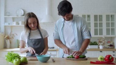 Genç mutlu çift mutfaklarında sağlıklı bir yemek hazırlıyor.