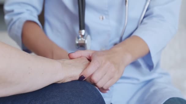 Doktor drží starší pacienty za ruce a uklidňuje ji — Stock video