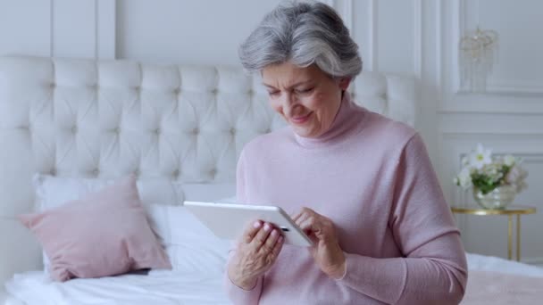 Mujer mayor que usa un dispositivo de tableta en casa — Vídeo de stock