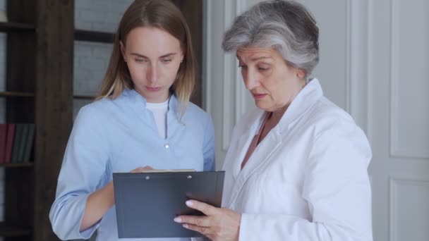 Two doctors communicate with each other in a medical office in a hospital — Stock Video