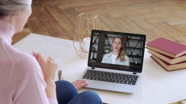 Sobre a visão do ombro de uma mulher idosa vídeo chamar uma filha jovem usando um smartphone. O conceito de videochamada familiar — Vídeo de Stock