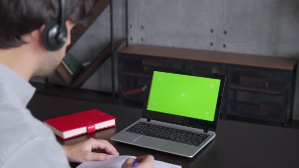 Biznesmen wideo czat online na laptopie z zielonym ekranem w biurze. Pracownik korporacyjny wywołuje wideo na laptopie w biurze. — Wideo stockowe