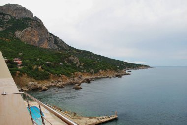 Yalı, taş, mavi gökyüzü arka plan üzerinde plaj yapılmış. Crimea.Black deniz. Deniz manzaralı otel.
