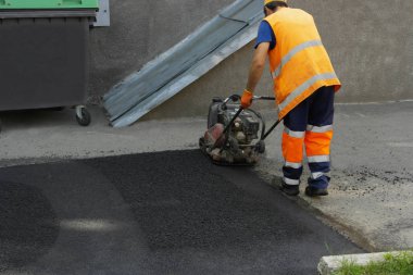 Plaka kompaktörler iasfalt döşeme. Asfalt döşenmesi, çukuru kaplaması, molozların üzerine.