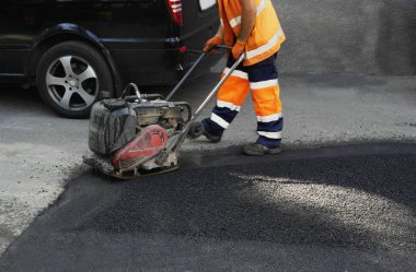 Plaka kompaktörler iasfalt döşeme. Asfalt döşenmesi, çukuru kaplaması, molozların üzerine.